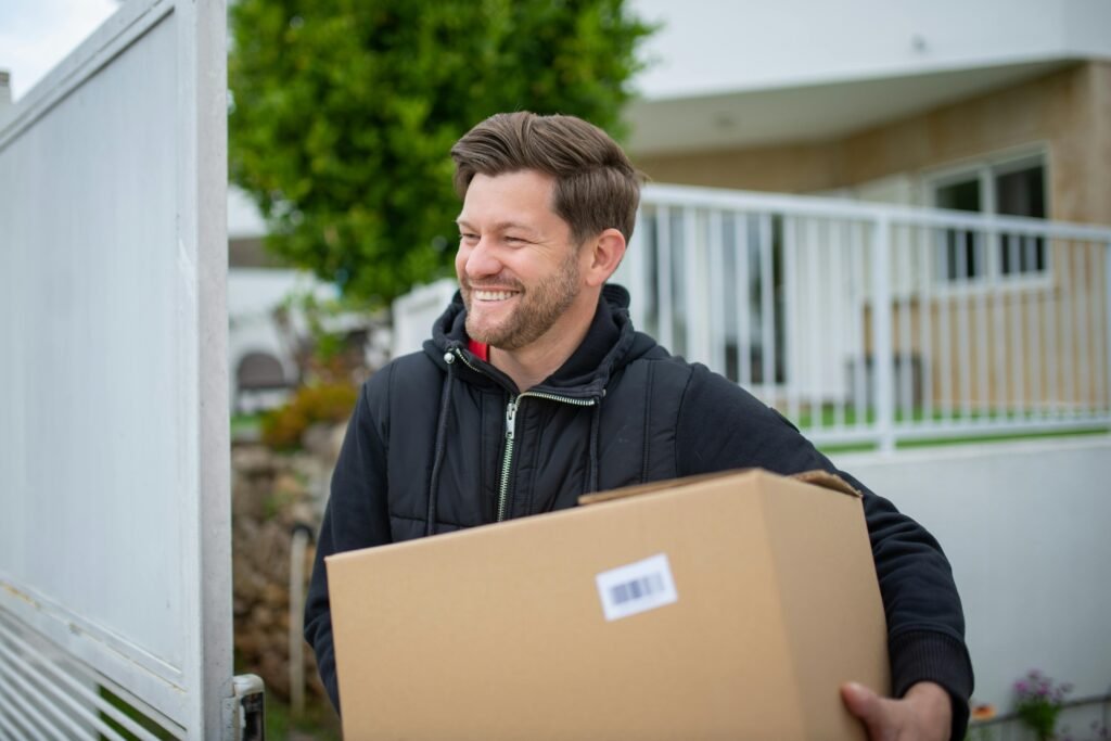 Man in Black Jacket Holding a Cardboard Box